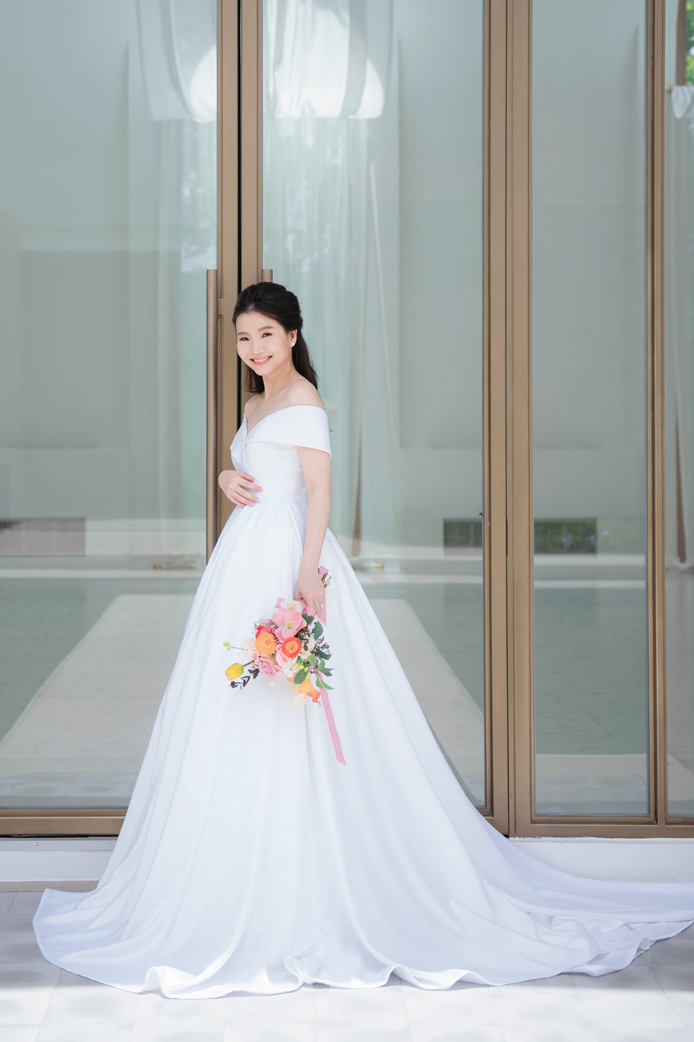 model wearing a white voluminous off-the-shoulder neckline wedding gown