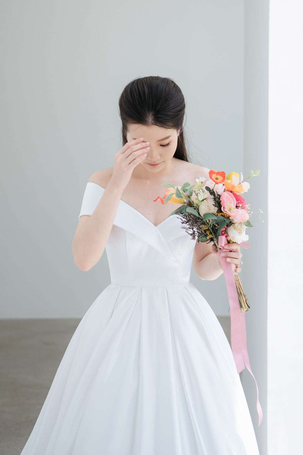model wearing a white voluminous off-the-shoulder neckline wedding gown