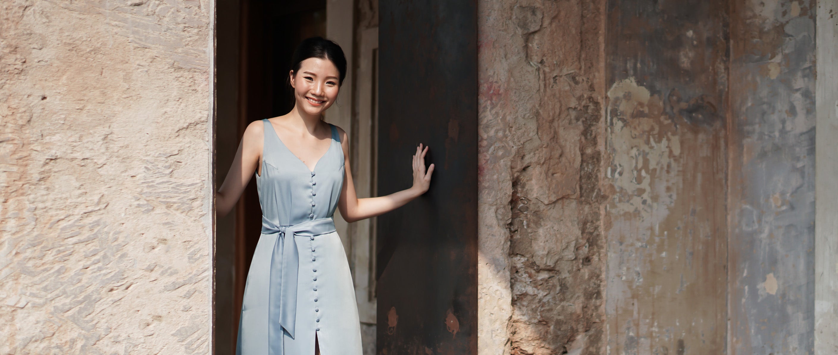 model wearing a blue sleeveless summer dress
