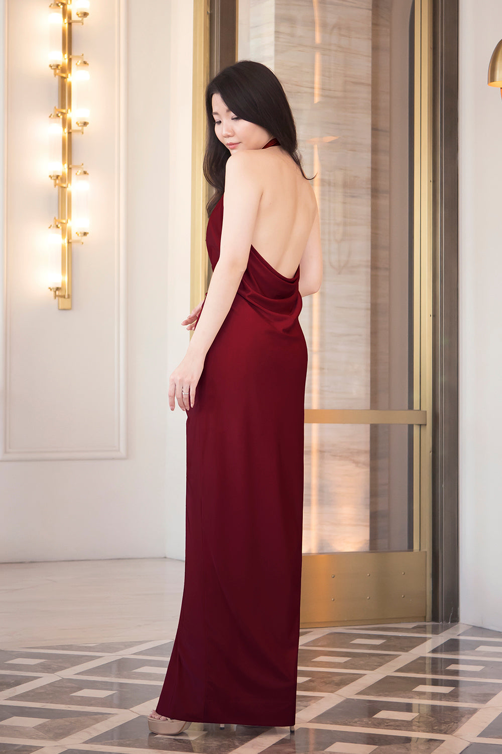 model in burgundy halter neck open back spandex evening dress