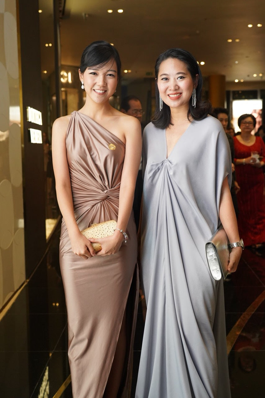 woman wearing a gold one shoulder wedding guest dress