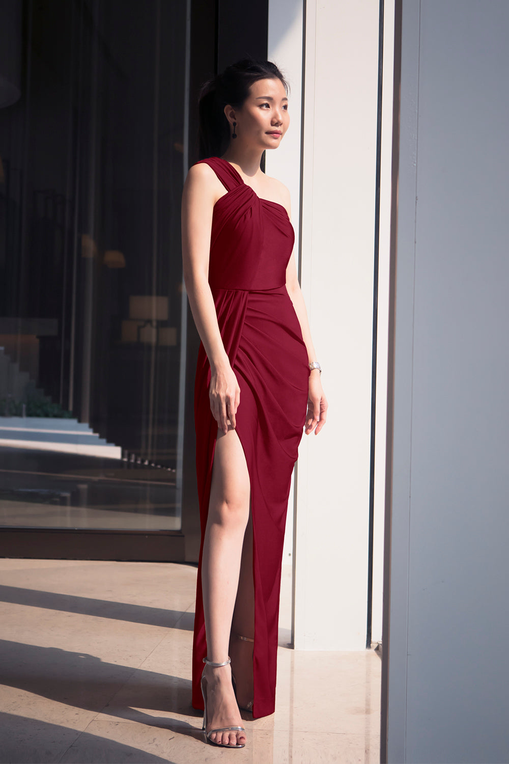 model in burgundy one-shoulder with an asymmetric column skirt spandex evening dress