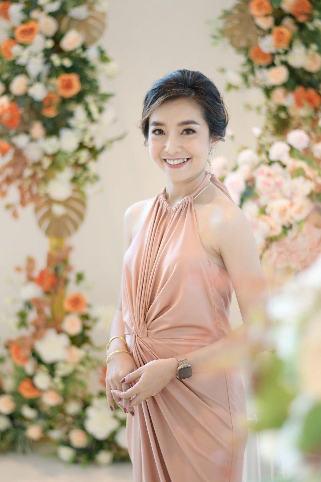 woman wearing a rose gold halter neck evening dress