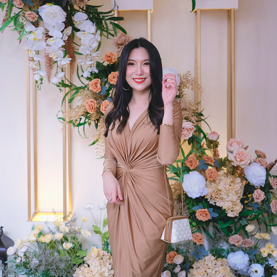 woman wearing a gold long sleeve cocktail dress