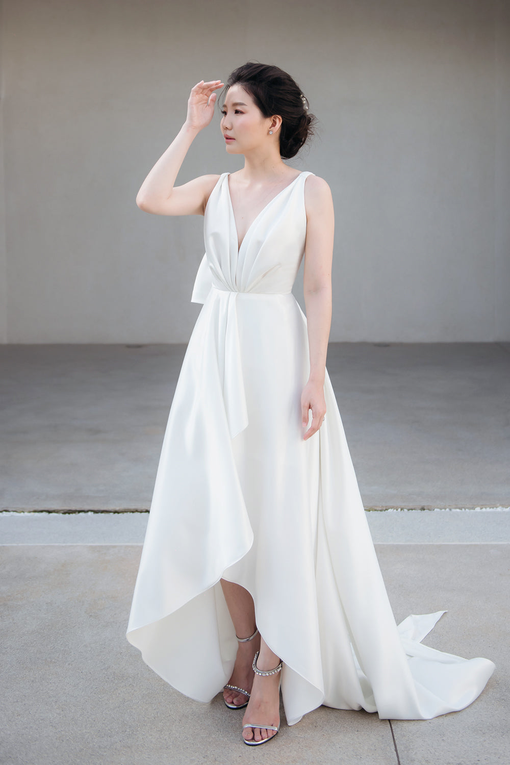 model wearing a white draped v neck minimal wedding gown 