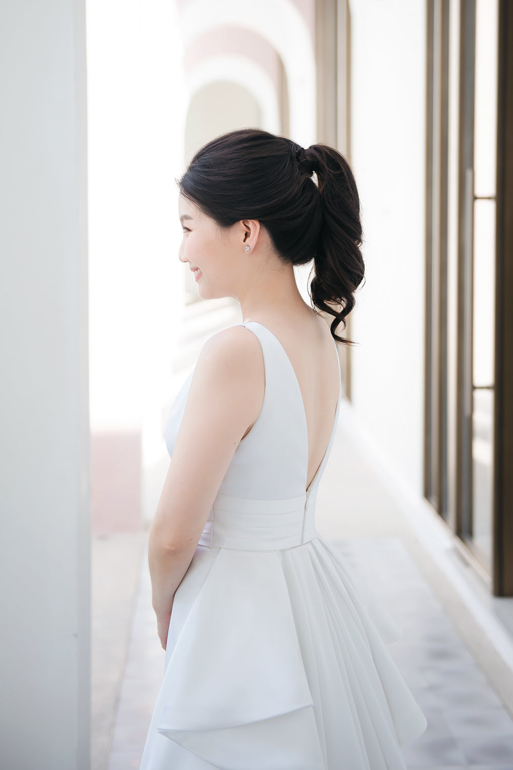 model wearing a white plunging v neck wedding gown with a detachable train