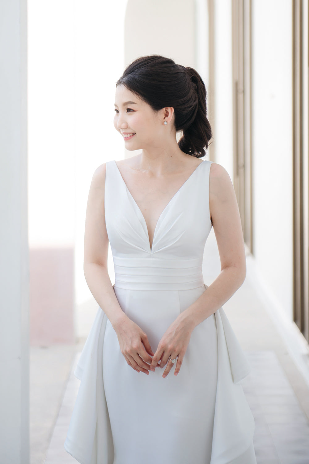 model wearing a white plunging v neck wedding gown with a detachable train