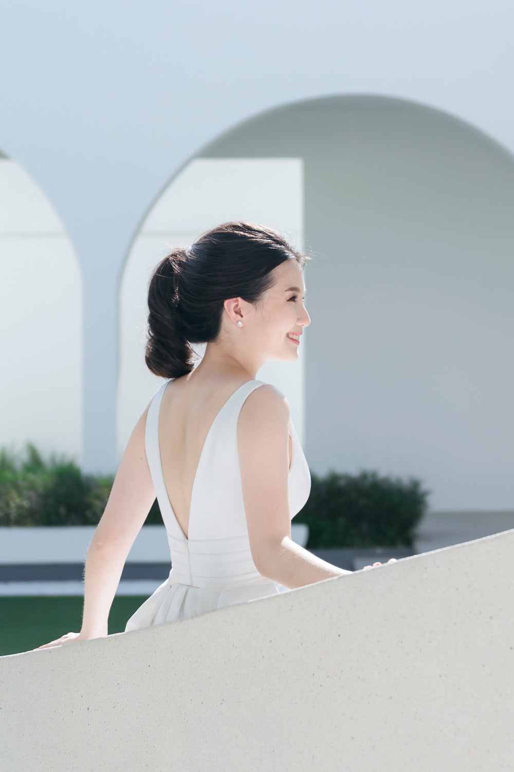 close up of a model wearing a white plunging v neck wedding gown with a detachable train