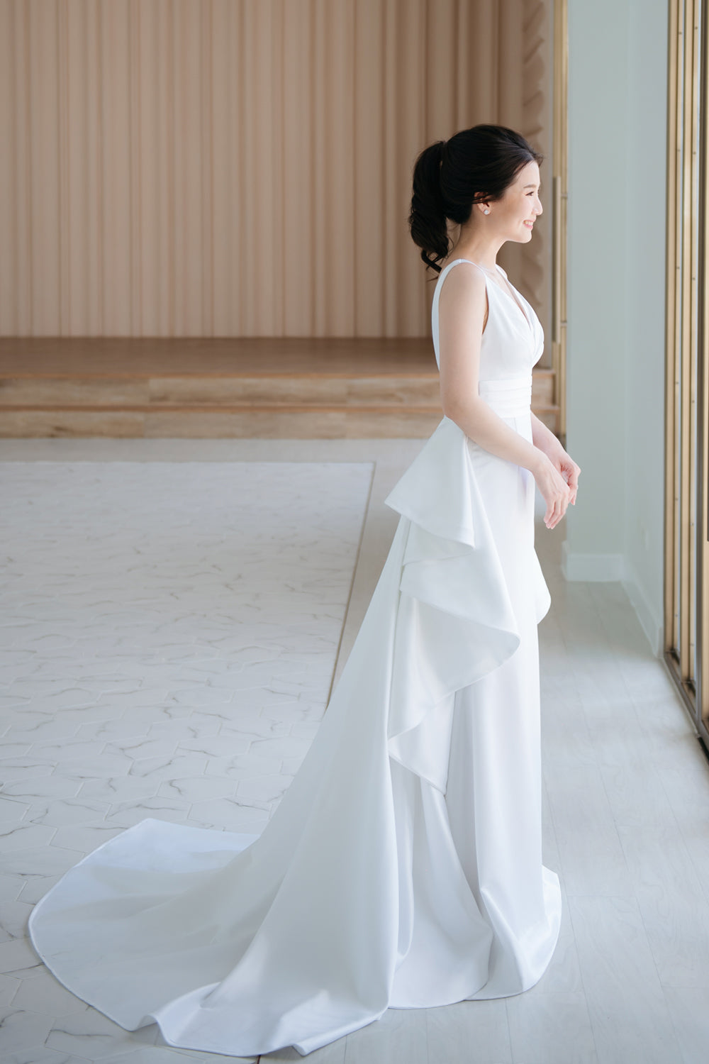 model wearing a white plunging v neck wedding gown with a detachable train