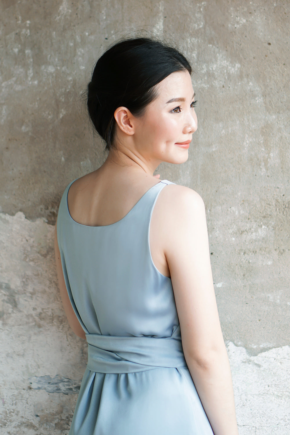 model wearing a frost blue casual sleeveless midi dress with dainty button detail