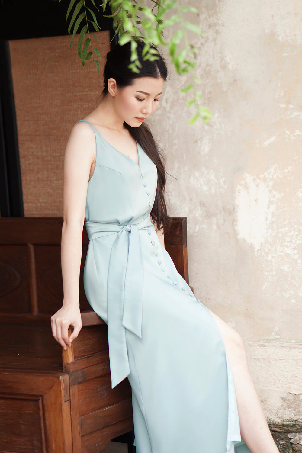 model wearing a muted teal casual v neck midi dress with dainty button detail