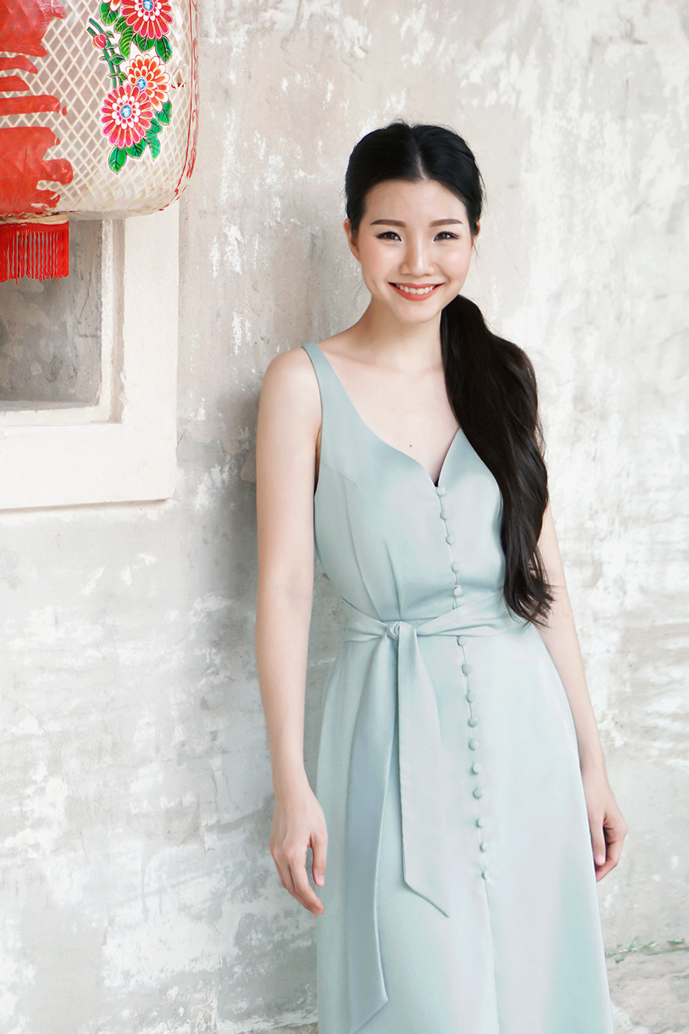 model wearing a muted teal casual v neck midi dress with dainty button detail