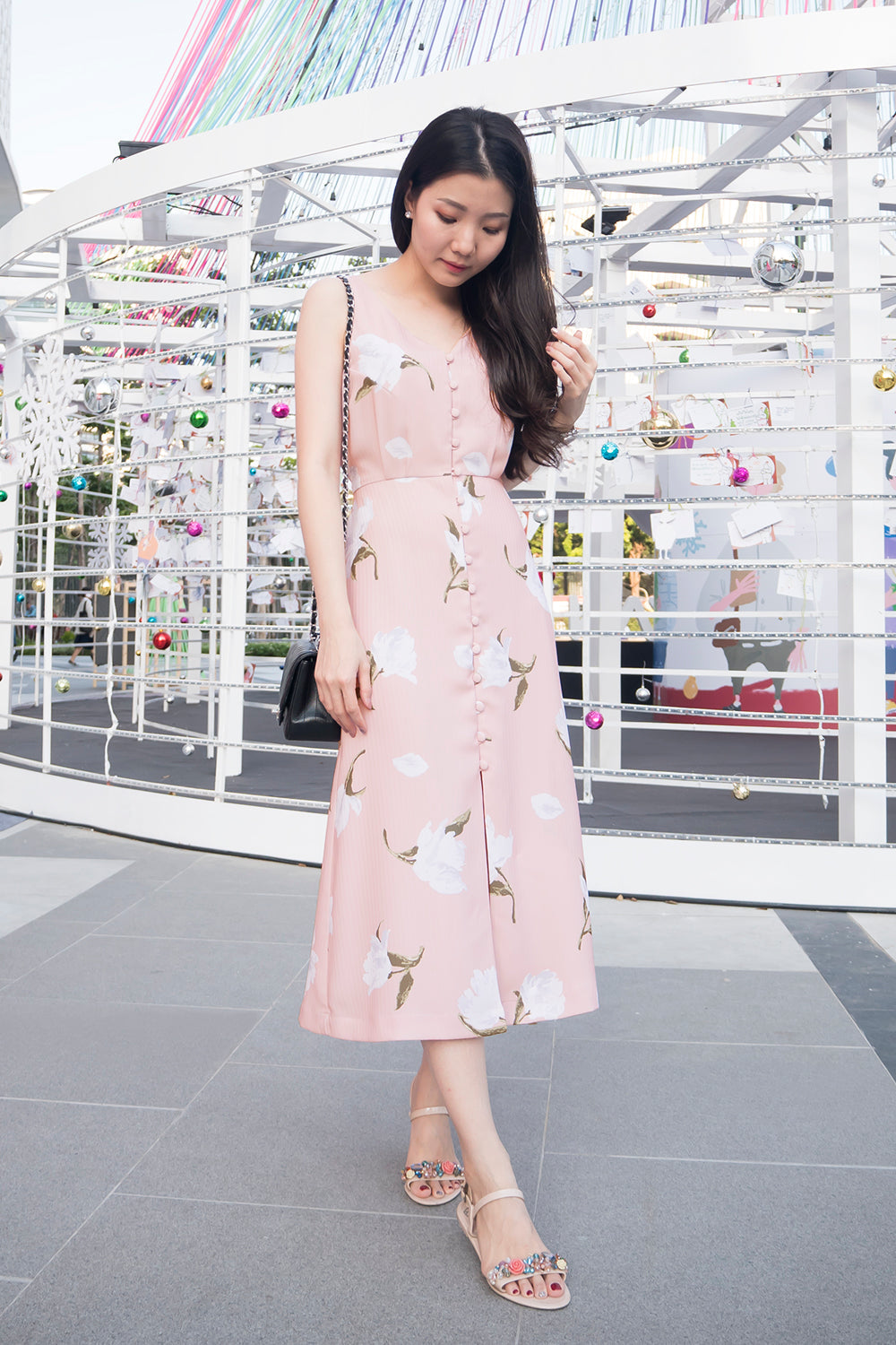 model wearing a pink floral print casual v neck midi dress with dainty button detail