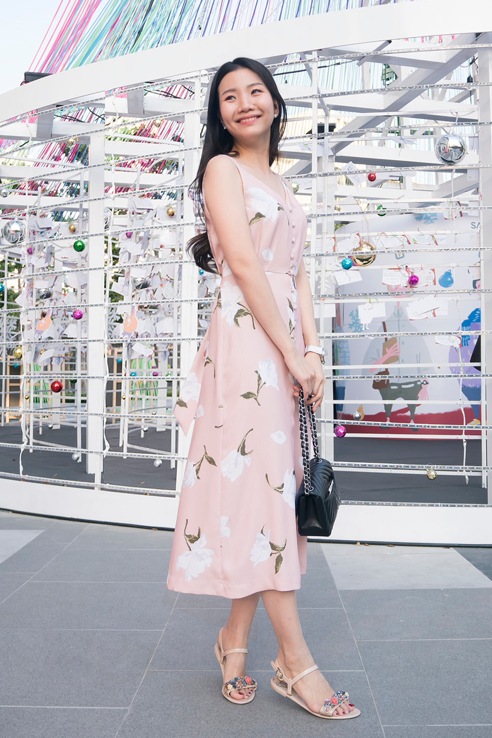 model wearing a pink floral print casual v neck midi dress with dainty button detail