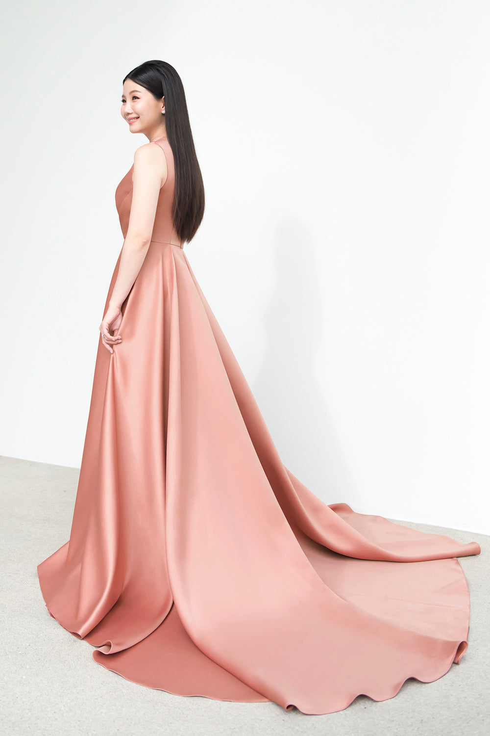 model wearing a one-shoulder full flair circle skirt minimal wedding gown in rosy beige color