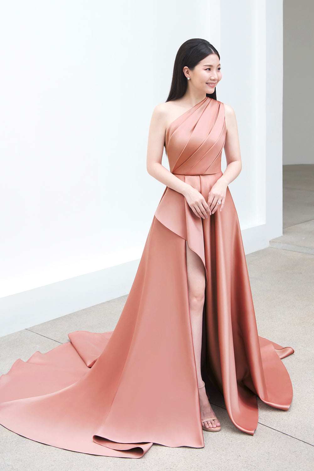 model wearing a one-shoulder full flair circle skirt minimal wedding gown in rosy beige color