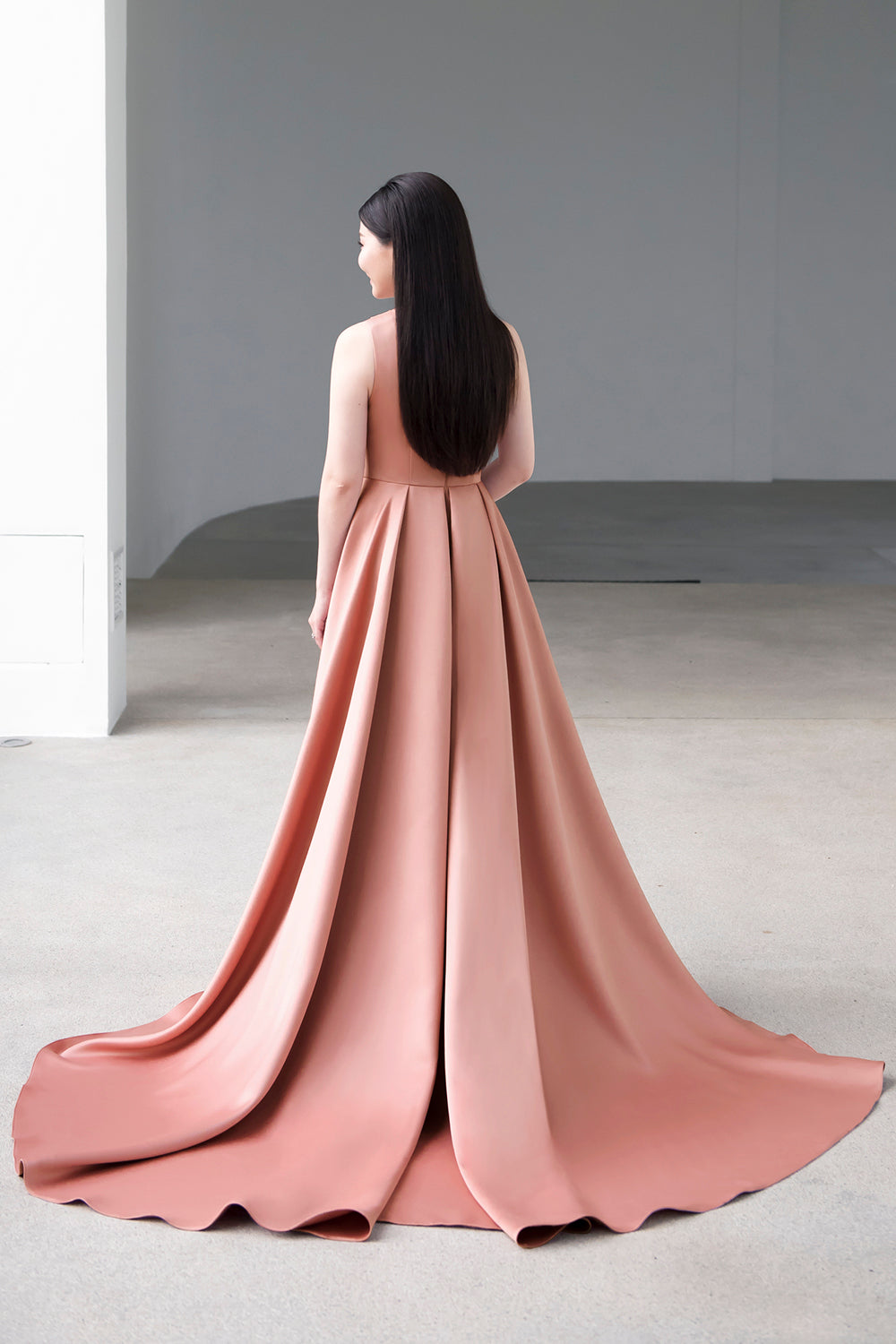 model wearing a one-shoulder full flair circle skirt minimal wedding gown in rosy beige color