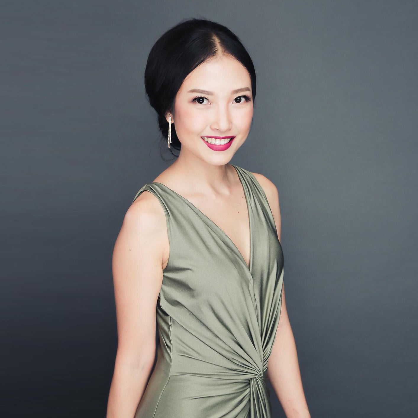 woman wearing a green v neck drape dress