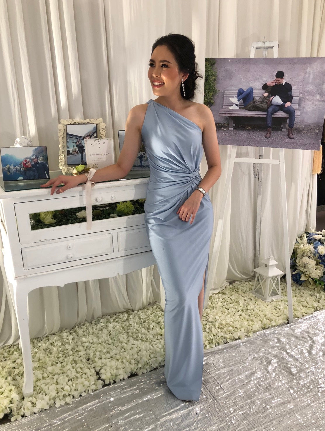 woman wearing a light blue one shoulder wedding guest dress