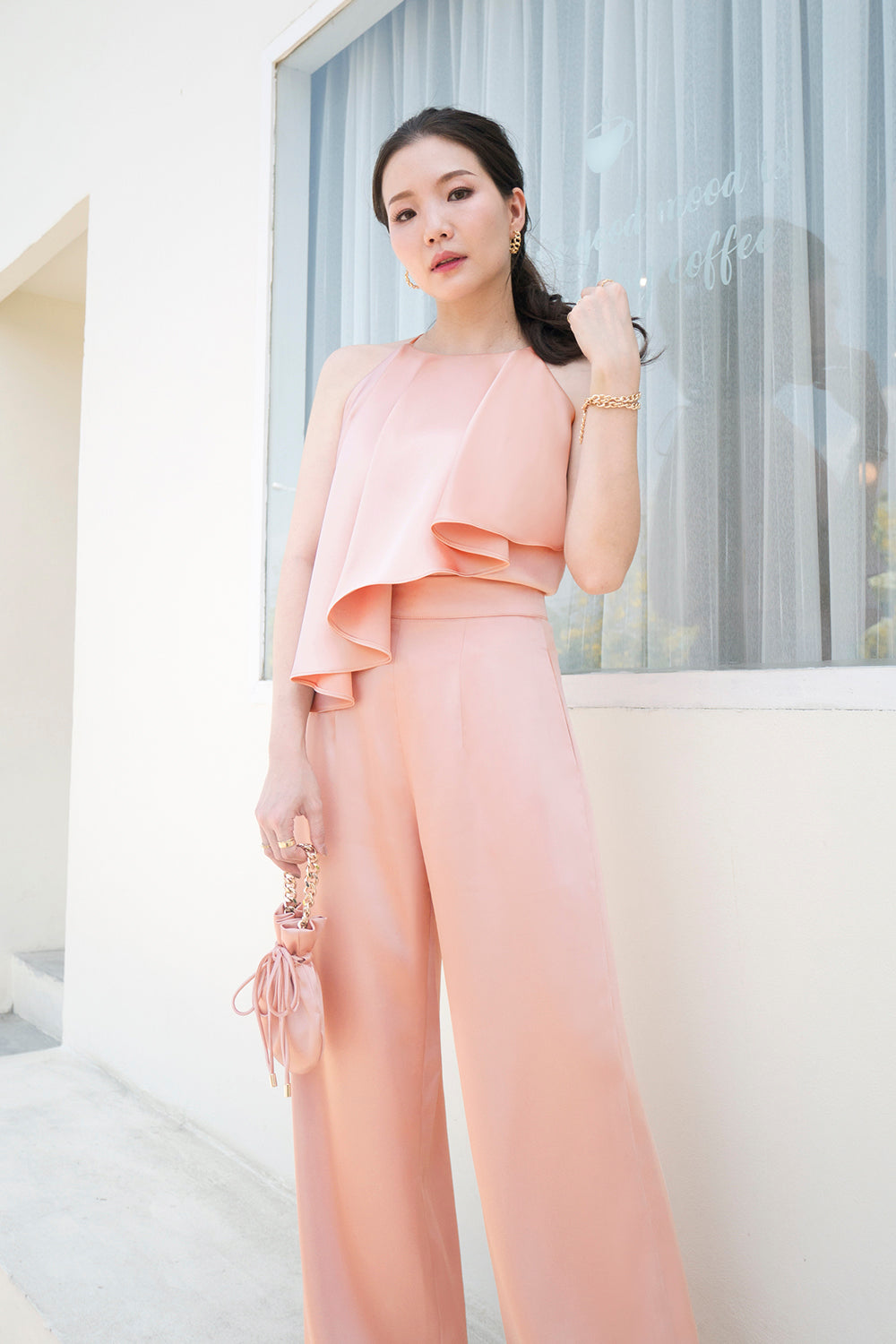 model wearing a coral pink halter neck top with matching high-waisted pants