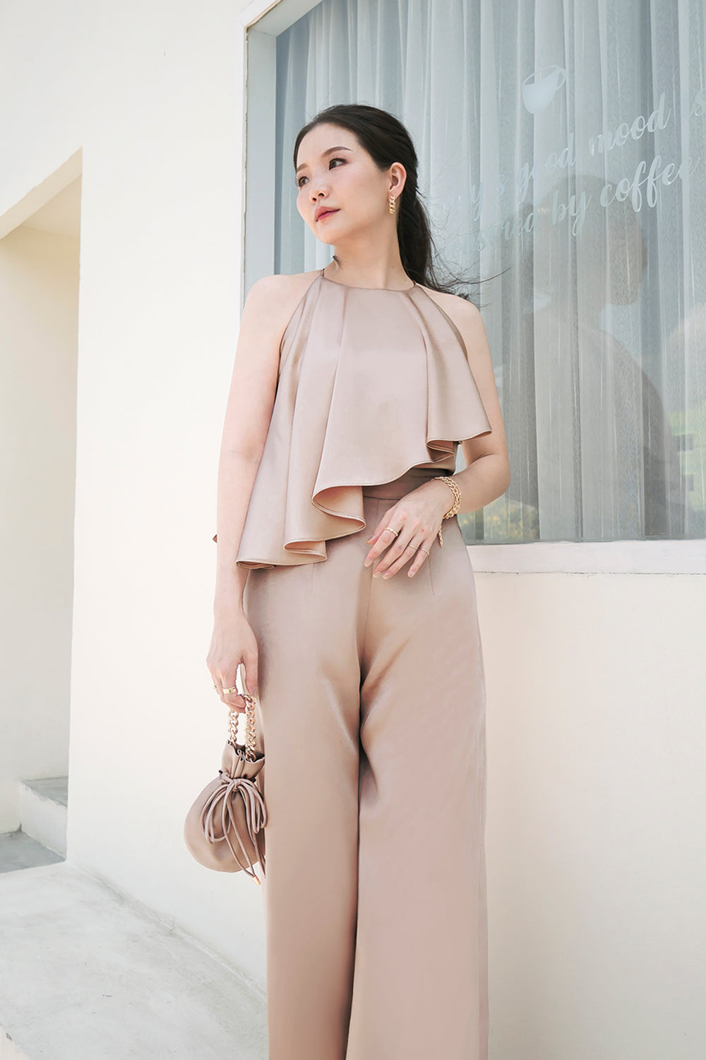 model wearing a light taupe halter neck top with matching high-waisted pants