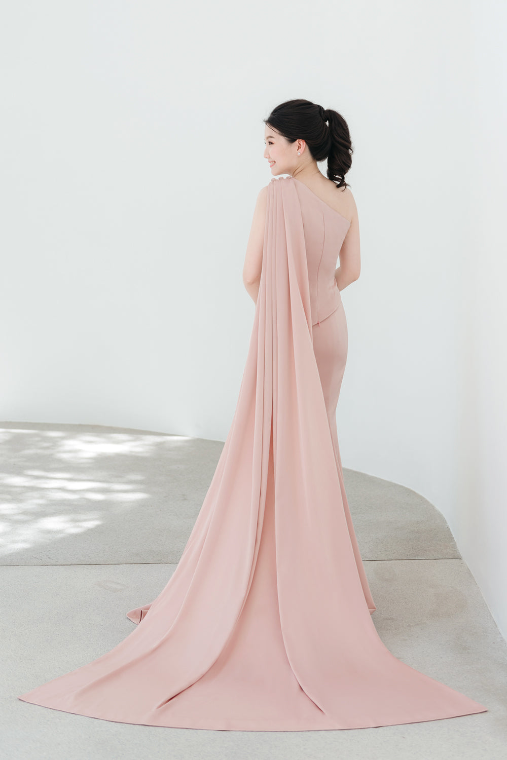 model wearing a one-shoulder two-piece set minimal wedding gown in nude pink color