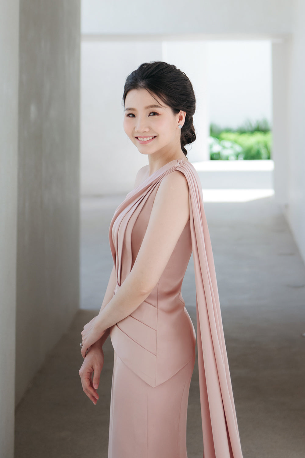 close up of a model wearing a one-shoulder two-piece set minimal wedding gown in nude pink color