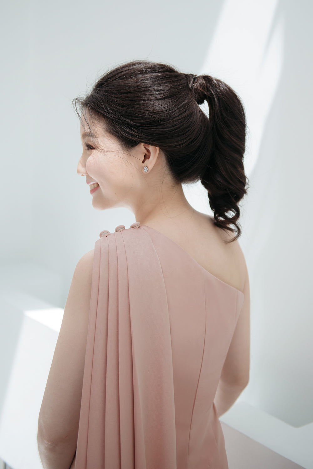 close up of a model wearing a one-shoulder two-piece set minimal wedding gown in nude pink color