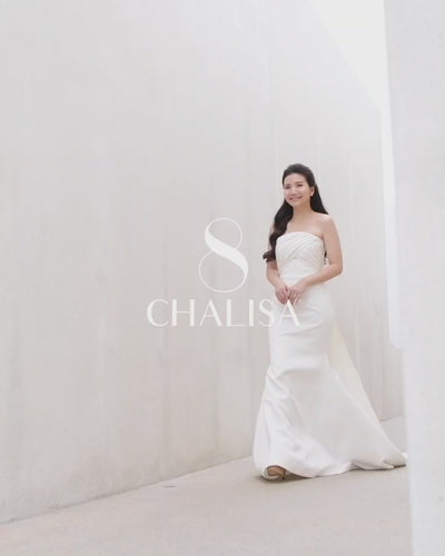 video of a model wearing a white strapless draped minimal wedding gown 