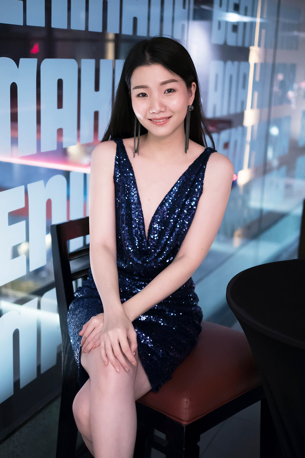 model wearing a glamorous open back navy sequin dress