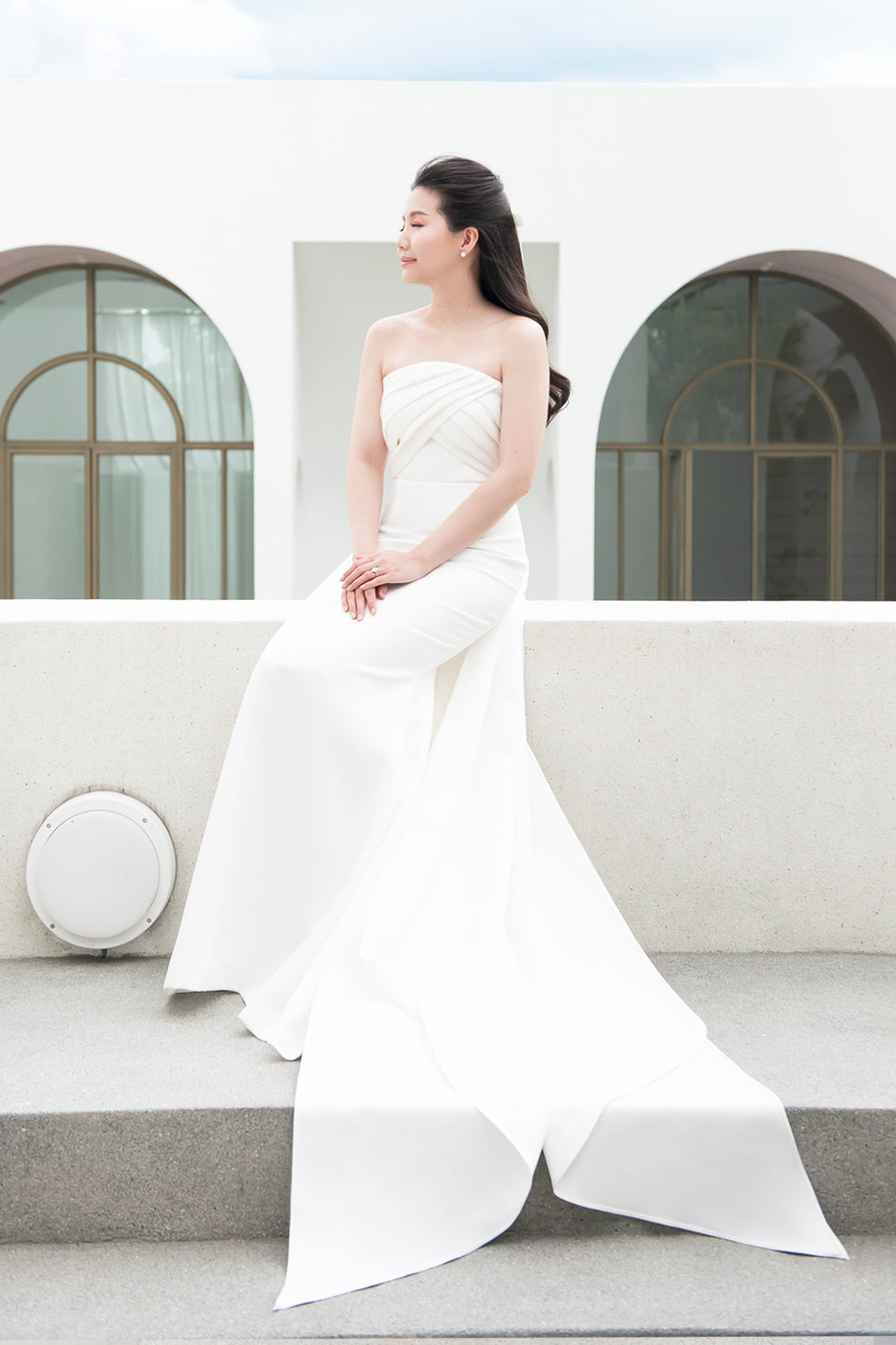 model wearing a white strapless draped minimal wedding gown 