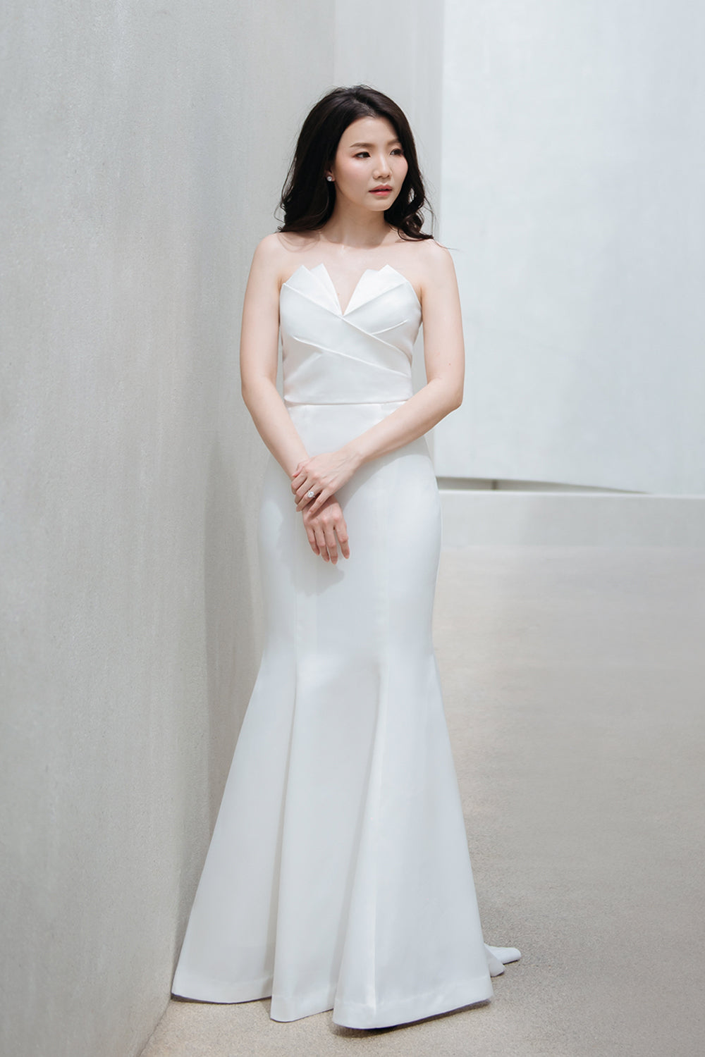 model wearing a white origami inspired strapless minimal wedding gown