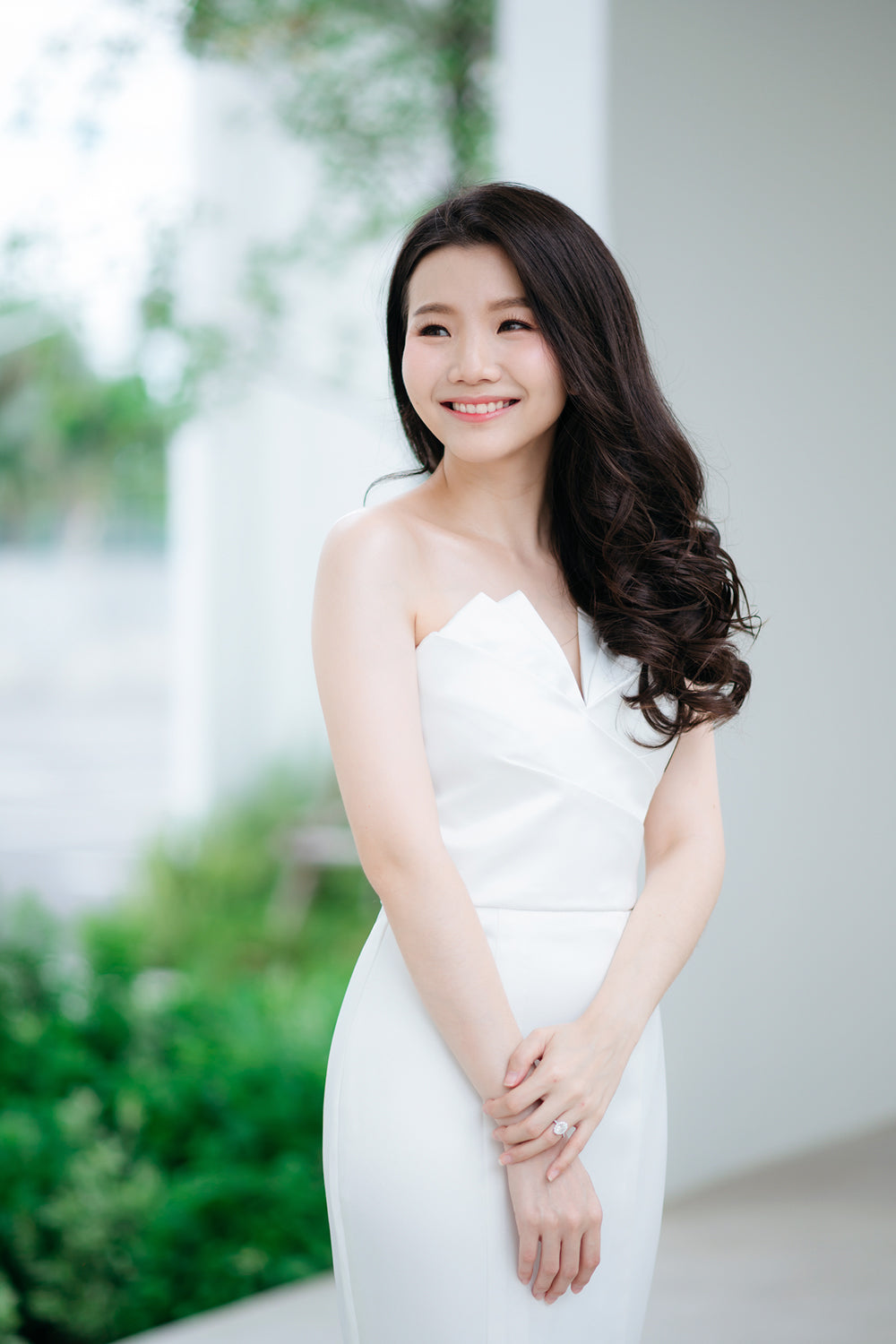 close up of a model wearing a white origami inspired strapless minimal wedding gown