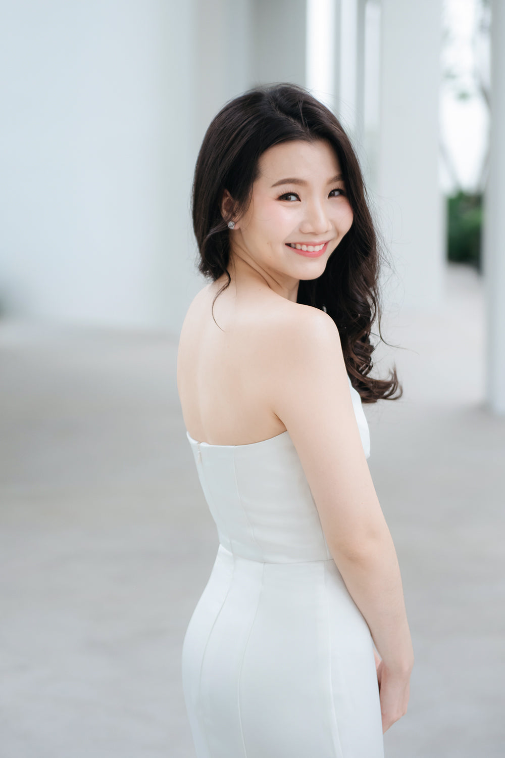 close up of a model wearing a white origami inspired strapless minimal wedding gown