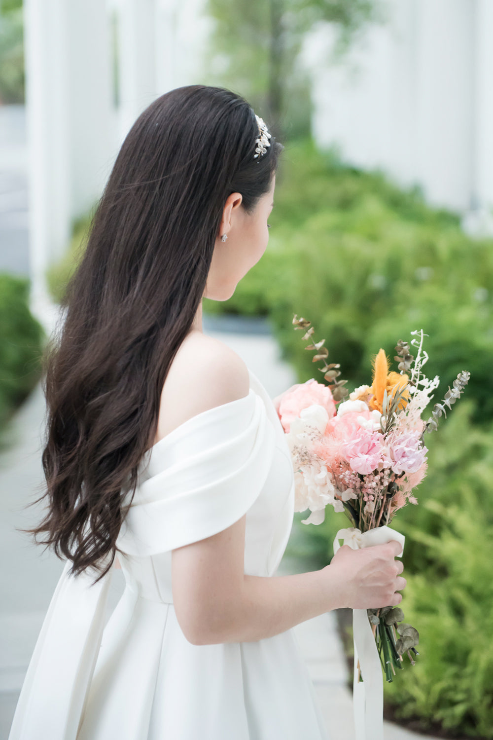 close up of a model wearing a white minimal wedding gown with 3D bodice drape details