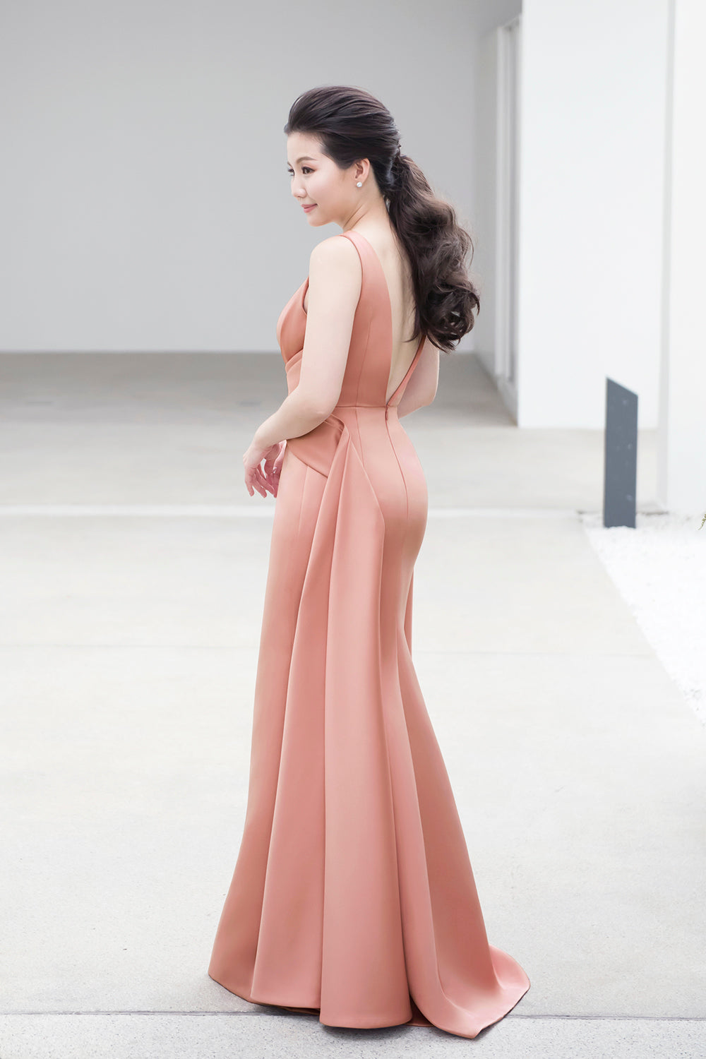 model wearing a plunging v neckline minimal wedding gown in rosy beige color