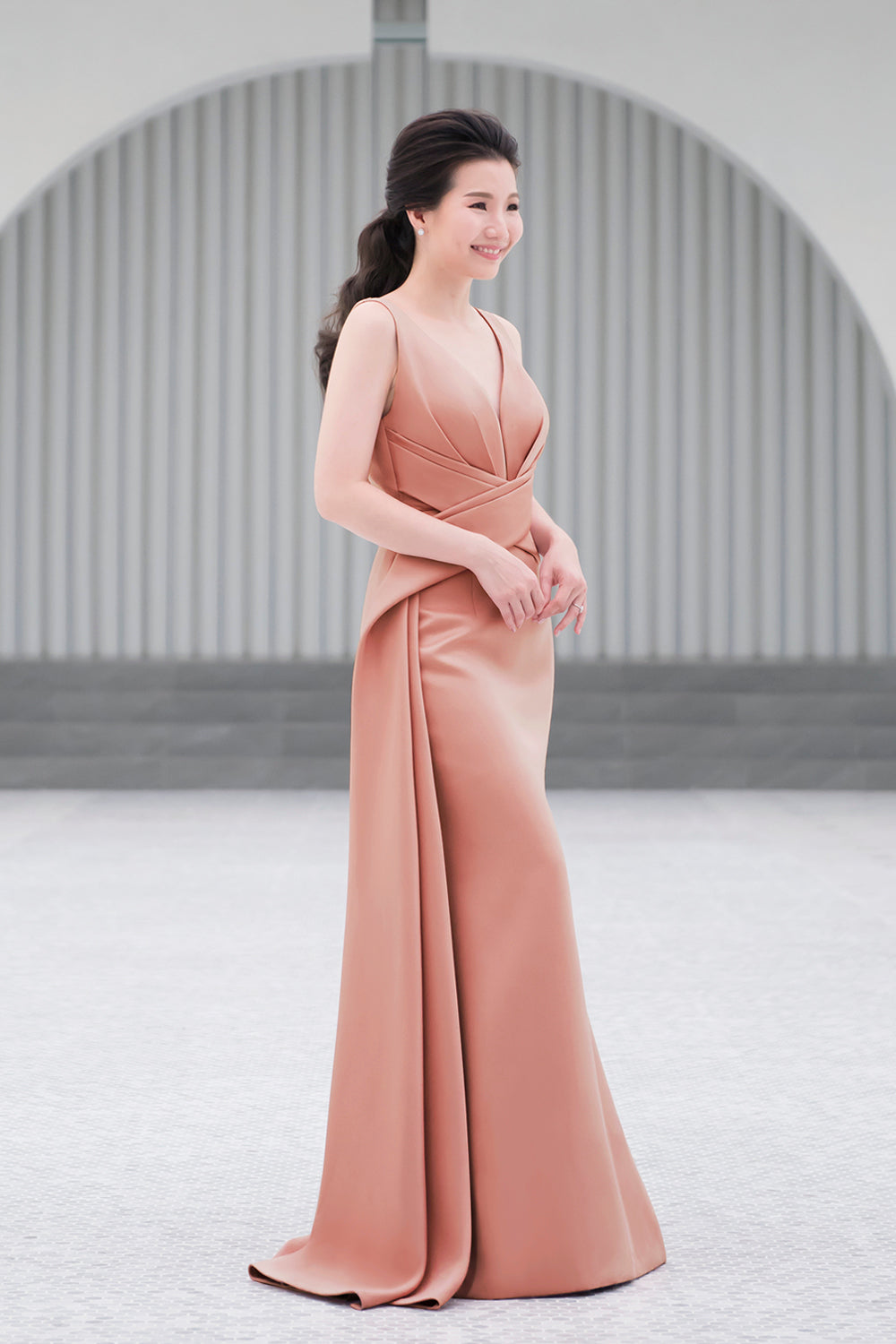 model wearing a plunging v neckline minimal wedding gown in rosy beige color