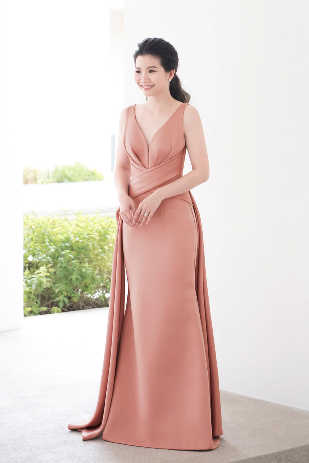 model wearing a plunging v neckline minimal wedding gown in rosy beige color