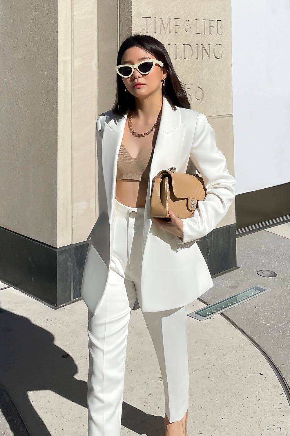 model wearing a white fitted silhouette blazer with a single button closure