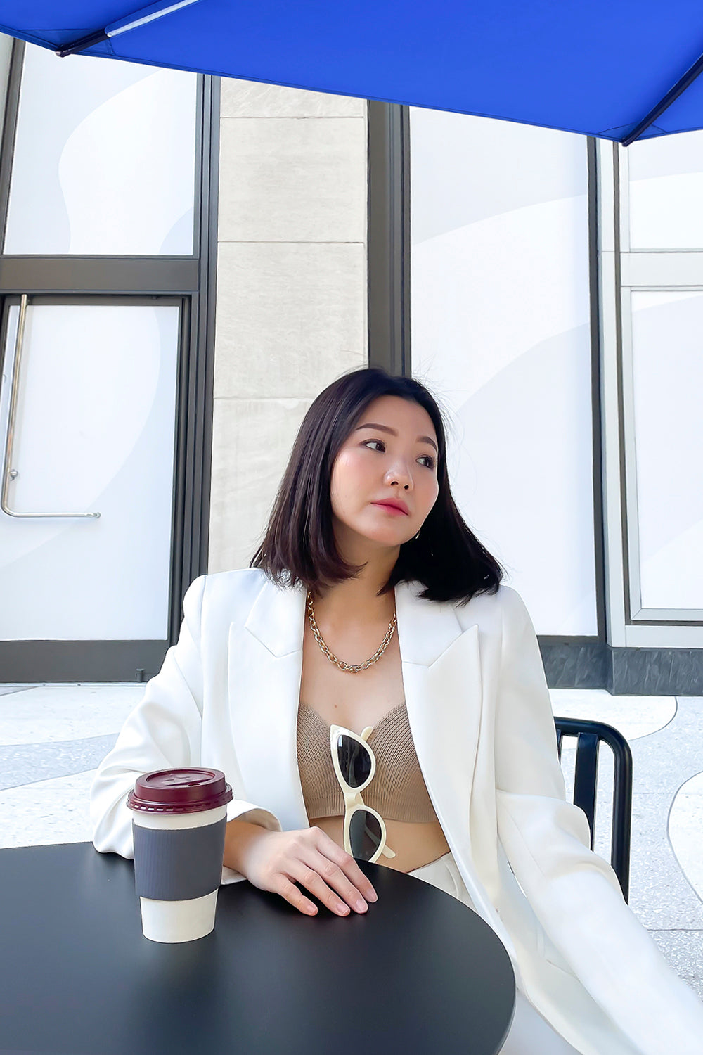 model wearing a white fitted silhouette blazer with a single button closure