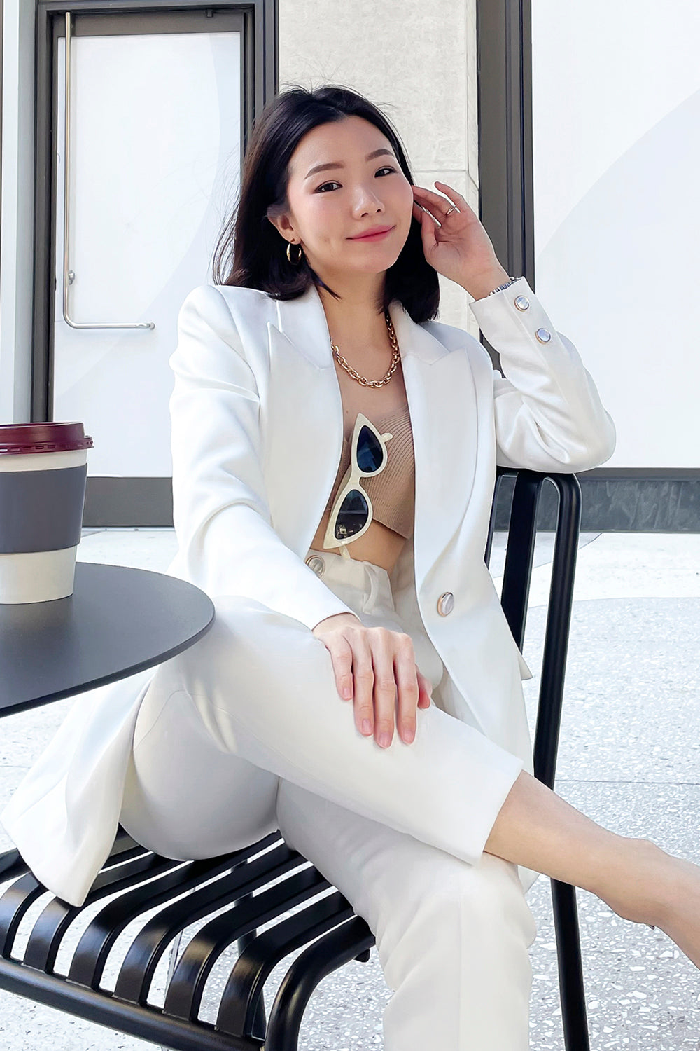 model wearing a white fitted silhouette blazer with a single button closure