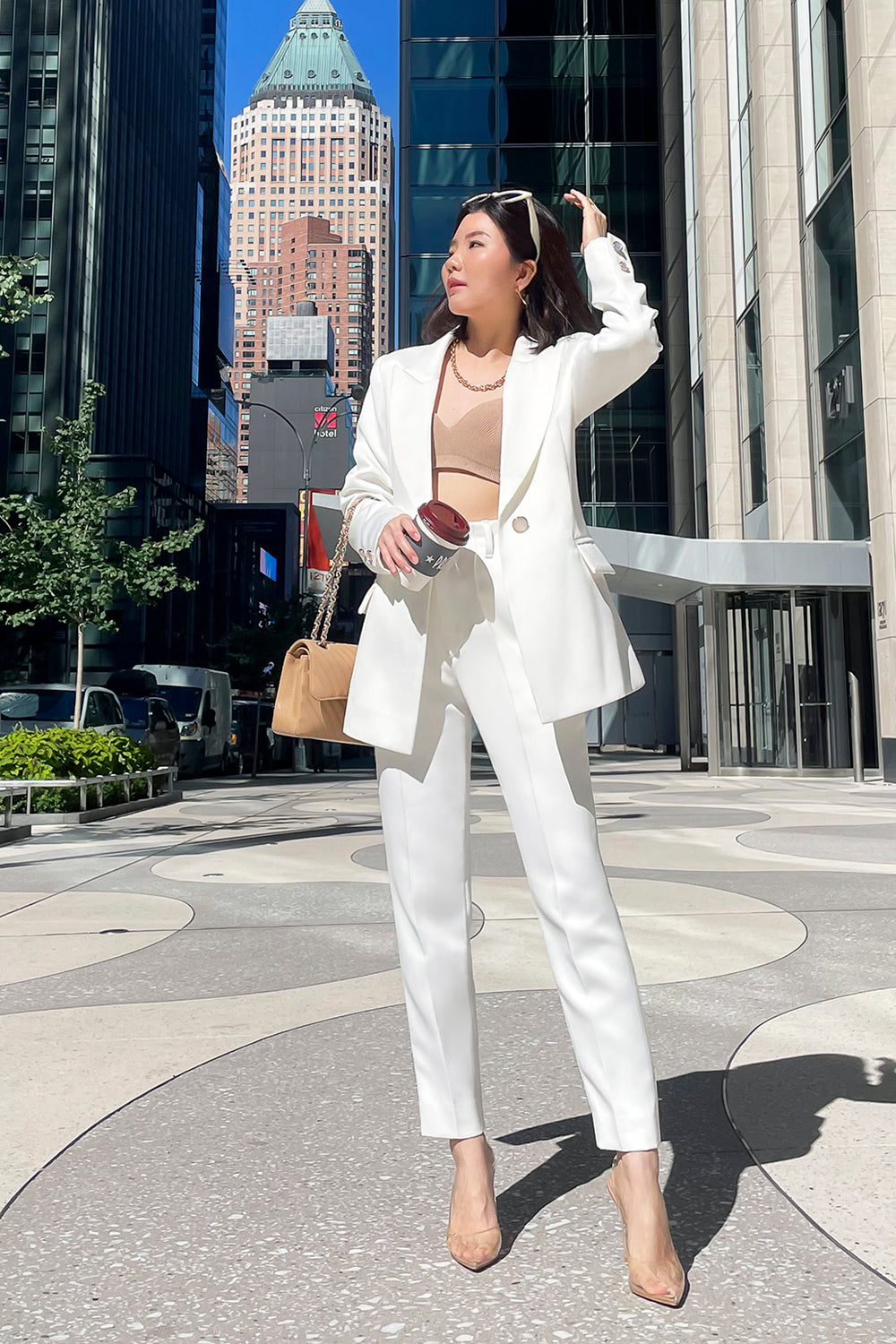 model wearing a white fitted silhouette blazer with a single button closure